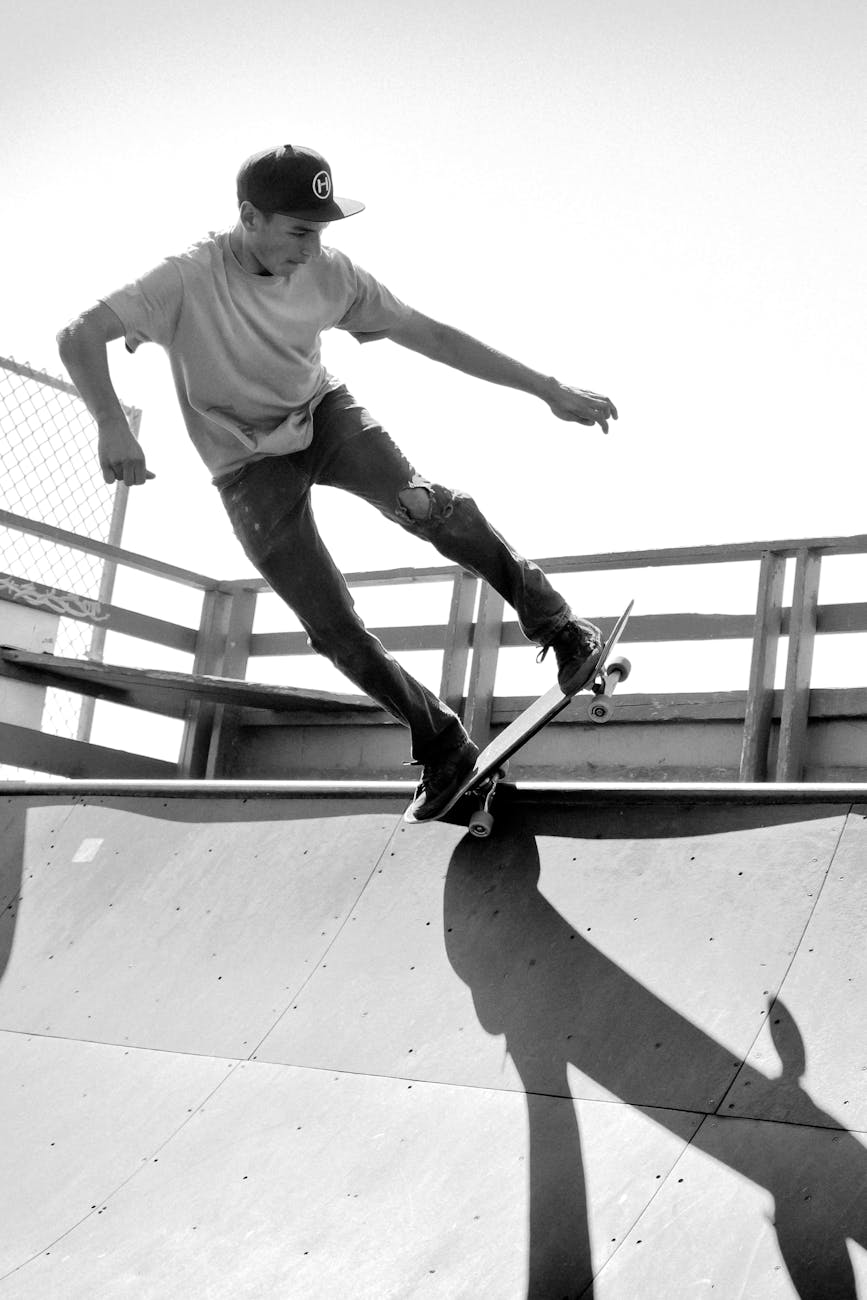 grayscale photography of man skateboarding on ramp